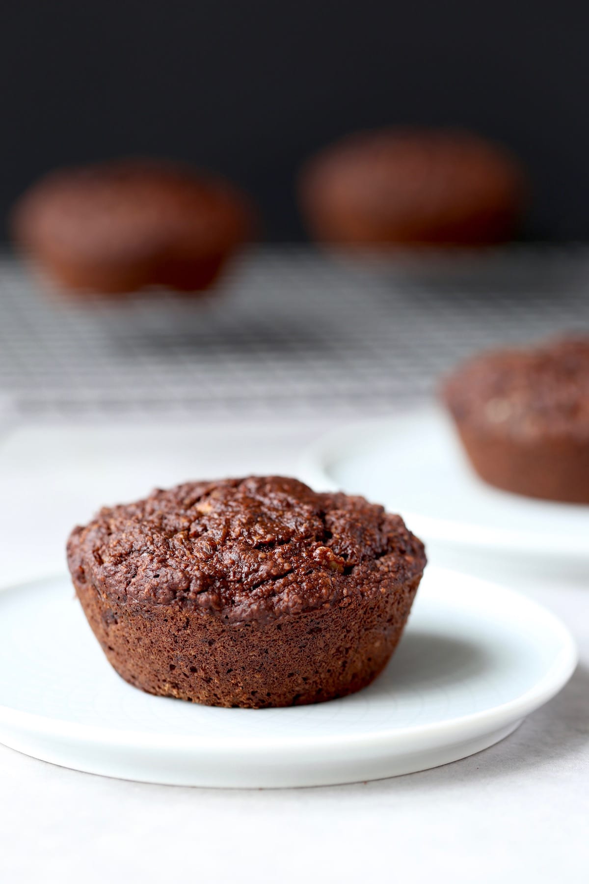 a jumbo vegan chocolate muffin on a plate that is also gluten free