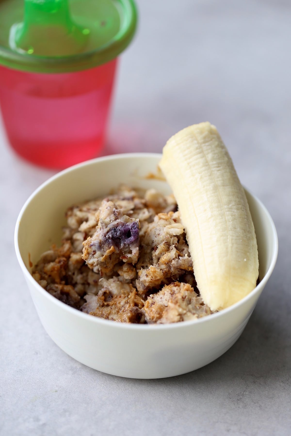 blueberry baked oatmeal in a kid bowl with half a banana