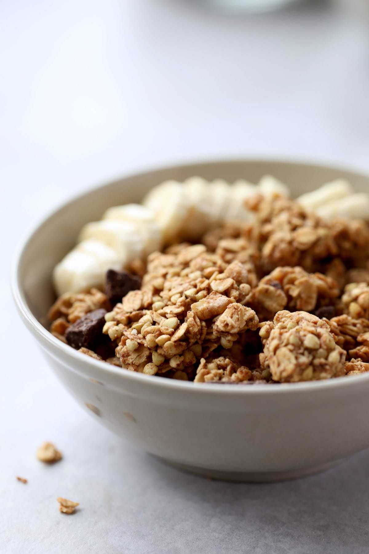 clustery peanut butter granola in a bowl with banana