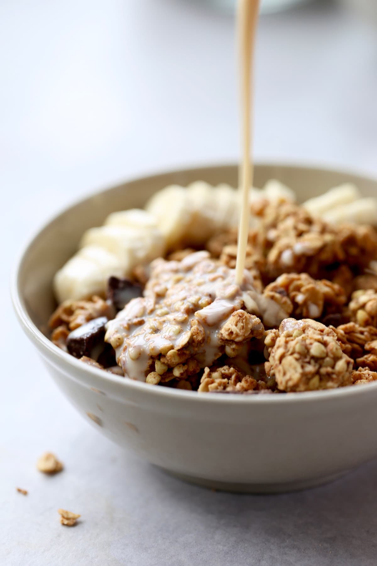 milk being poured on peanut butter granola