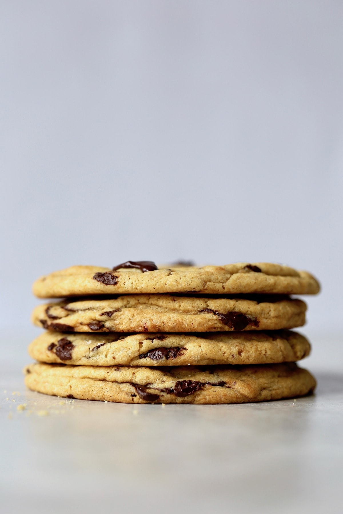 four bakery style chocolate chip cookies stacked on each other