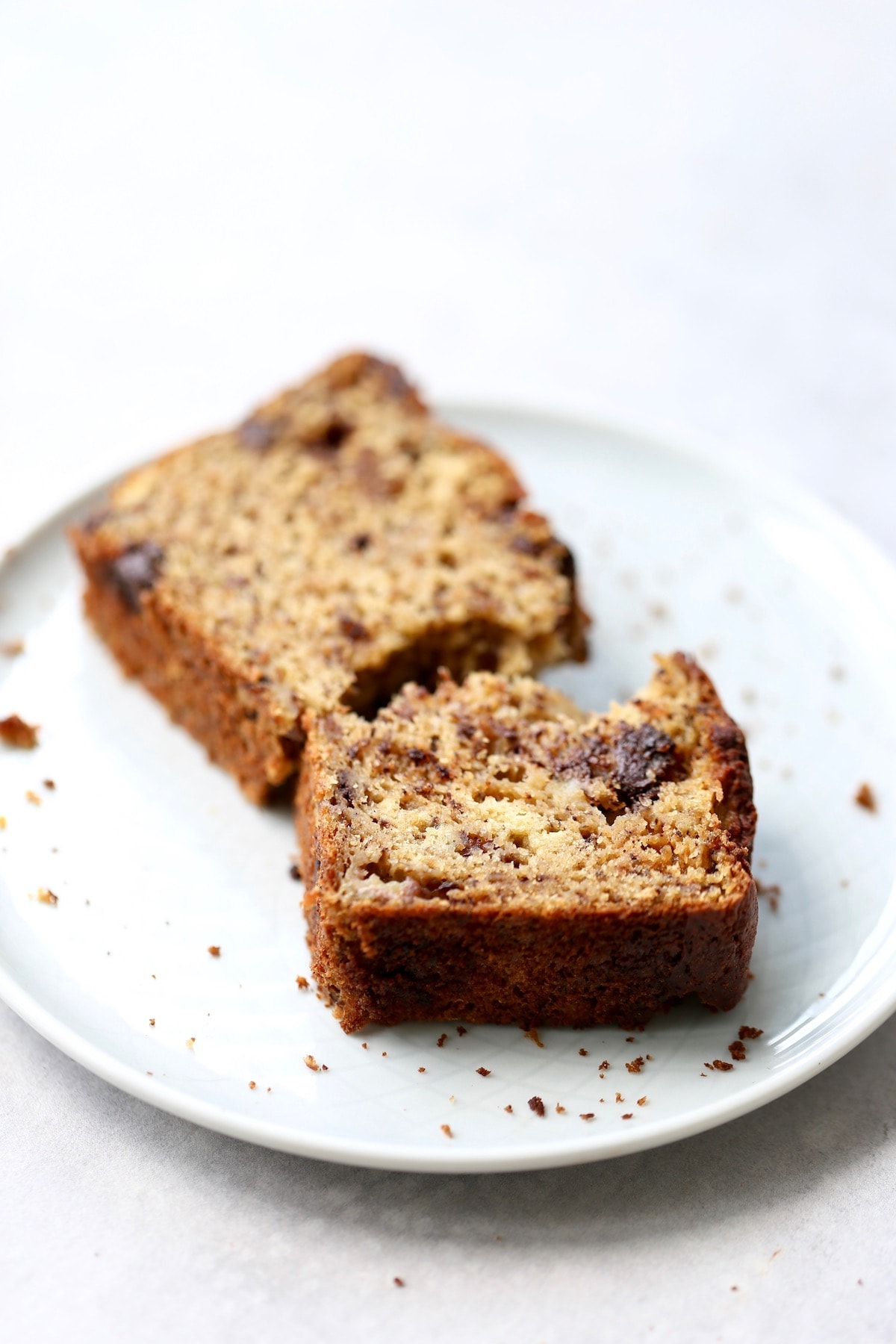 a broken piece of chocolate banana bread on a plate