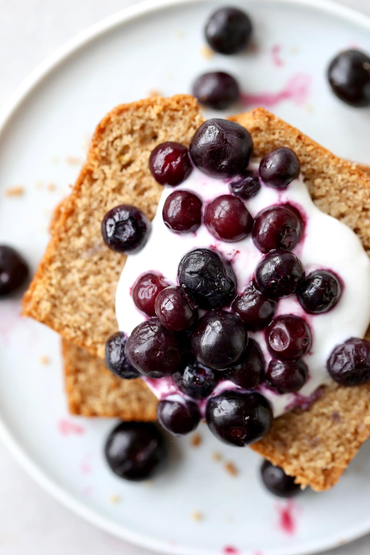 Vegan Whole Wheat Olive Oil Tea Cake topped frosting and fresh blueberries