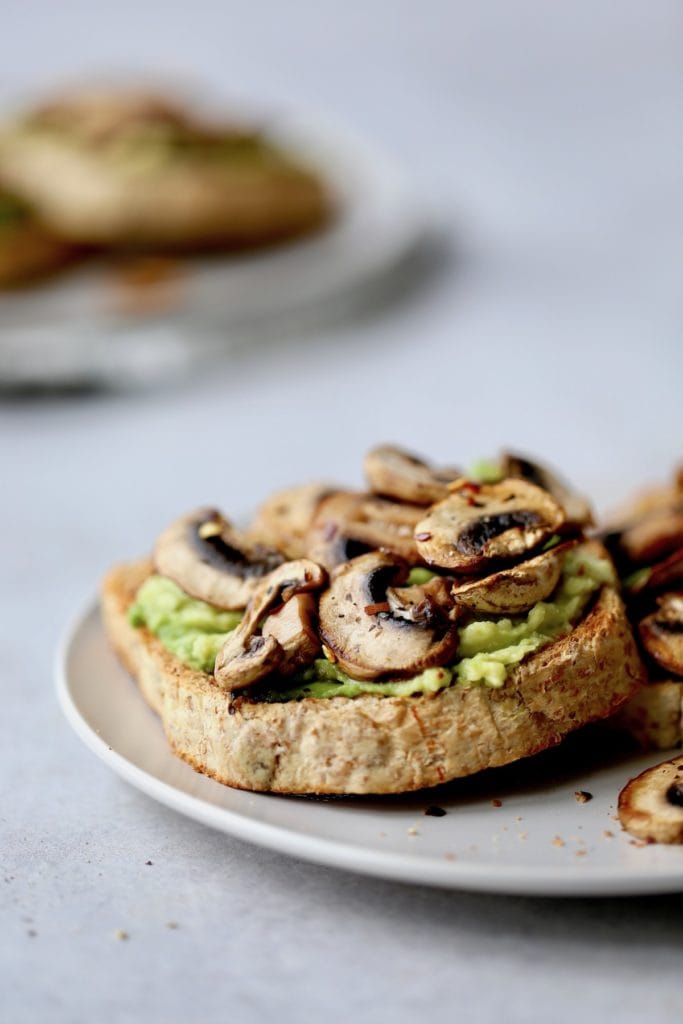 marmite avocado toast topped with sauteed mushrooms