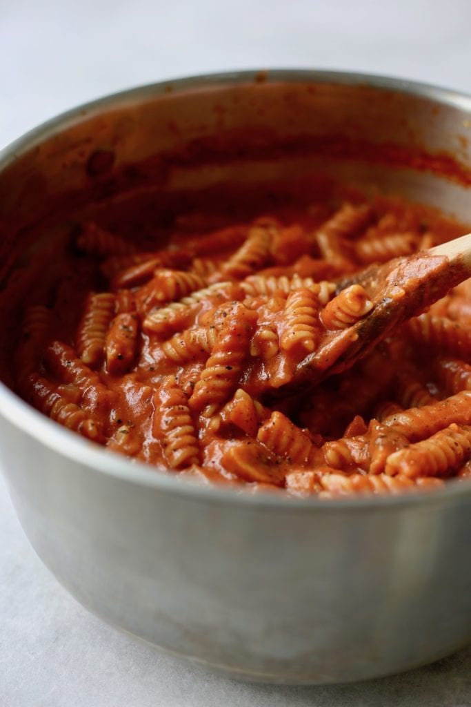 One-Pot Creamy marinara pasta being stirred in a pot