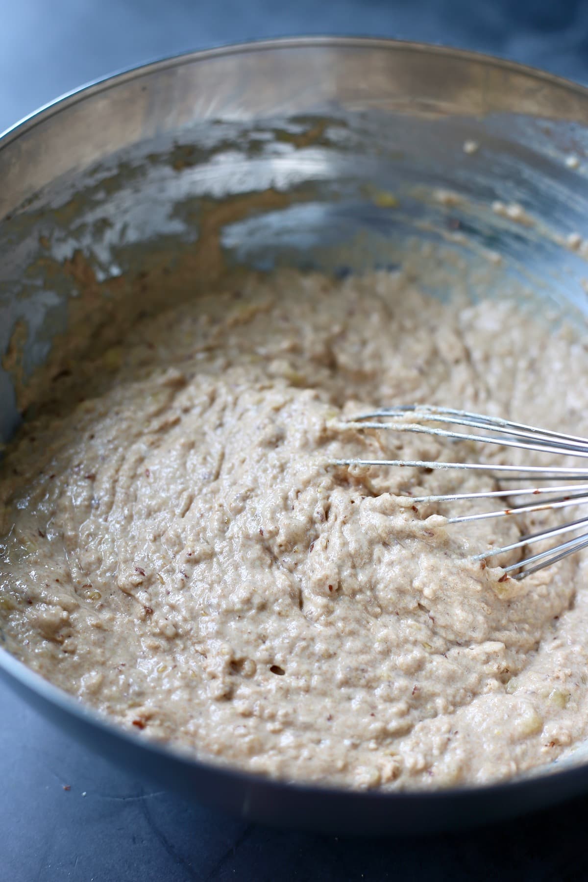 whole wheat vegan banana pancake batter being whisked in a bowl