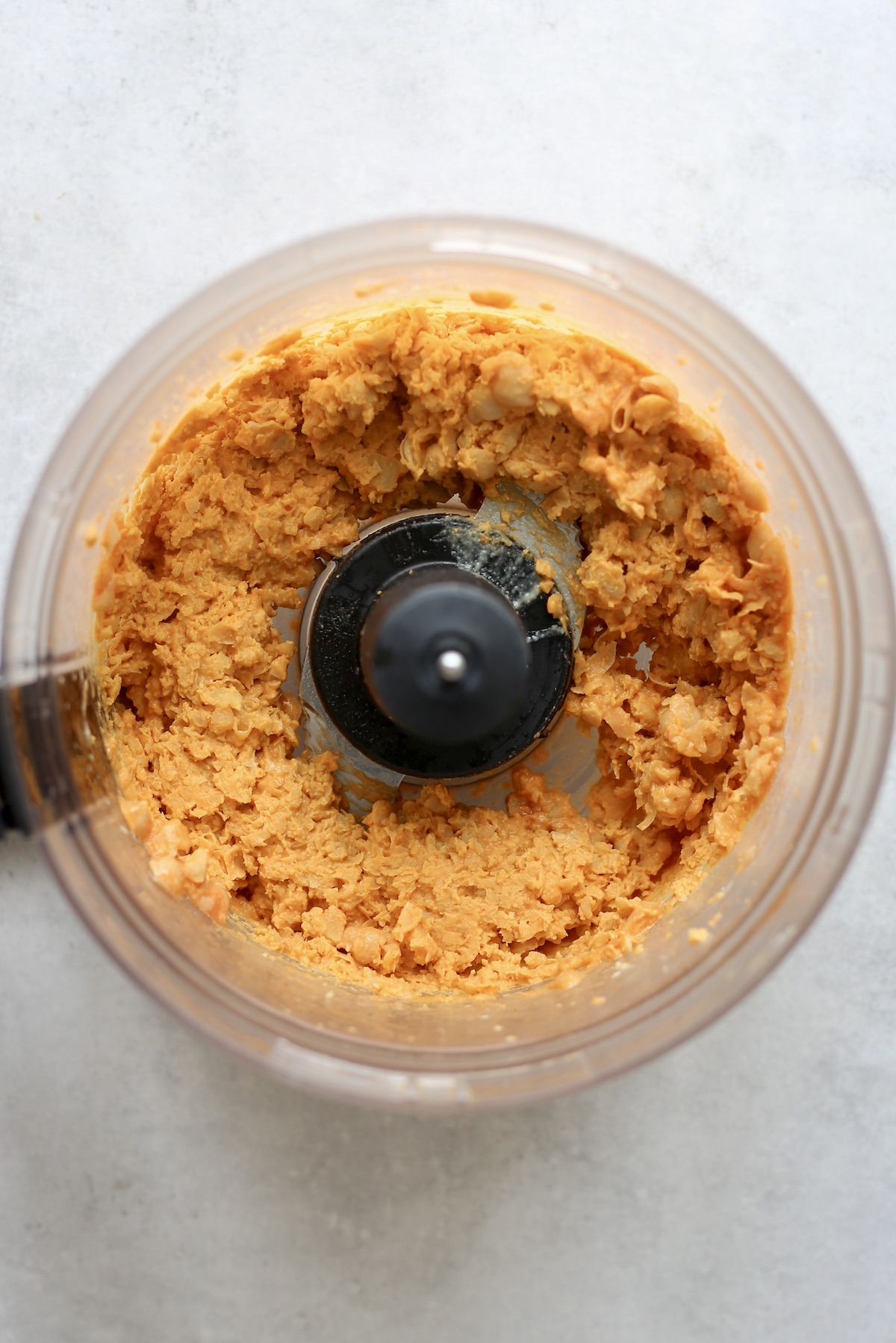 Chickpeas, hot sauce and tahini processed into a chunky dip in a food processor. 