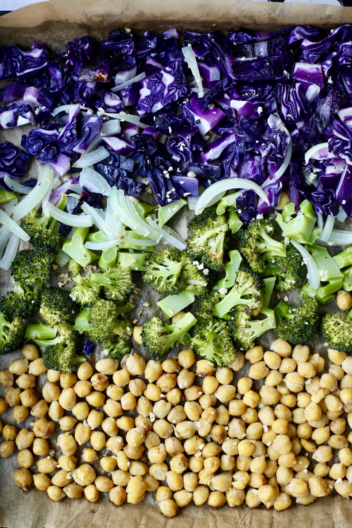 raw veggies and chickpeas on a sheet pan before going into the oven to roast