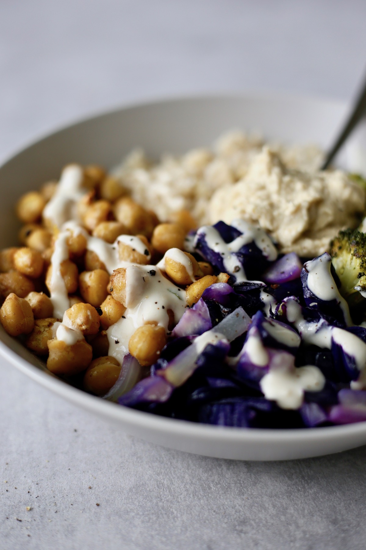 Chickpea and Broccoli sheet pan dinner loaded into a bowl with brown rice and tahini dressing