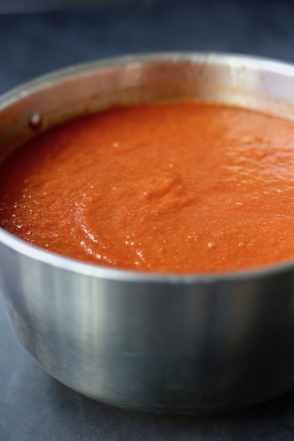 Creamy tomato soup in a silver sauce pan.