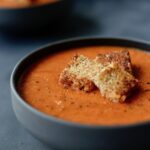 creamy tomato zucchini soup topped with grilled cheese croutons