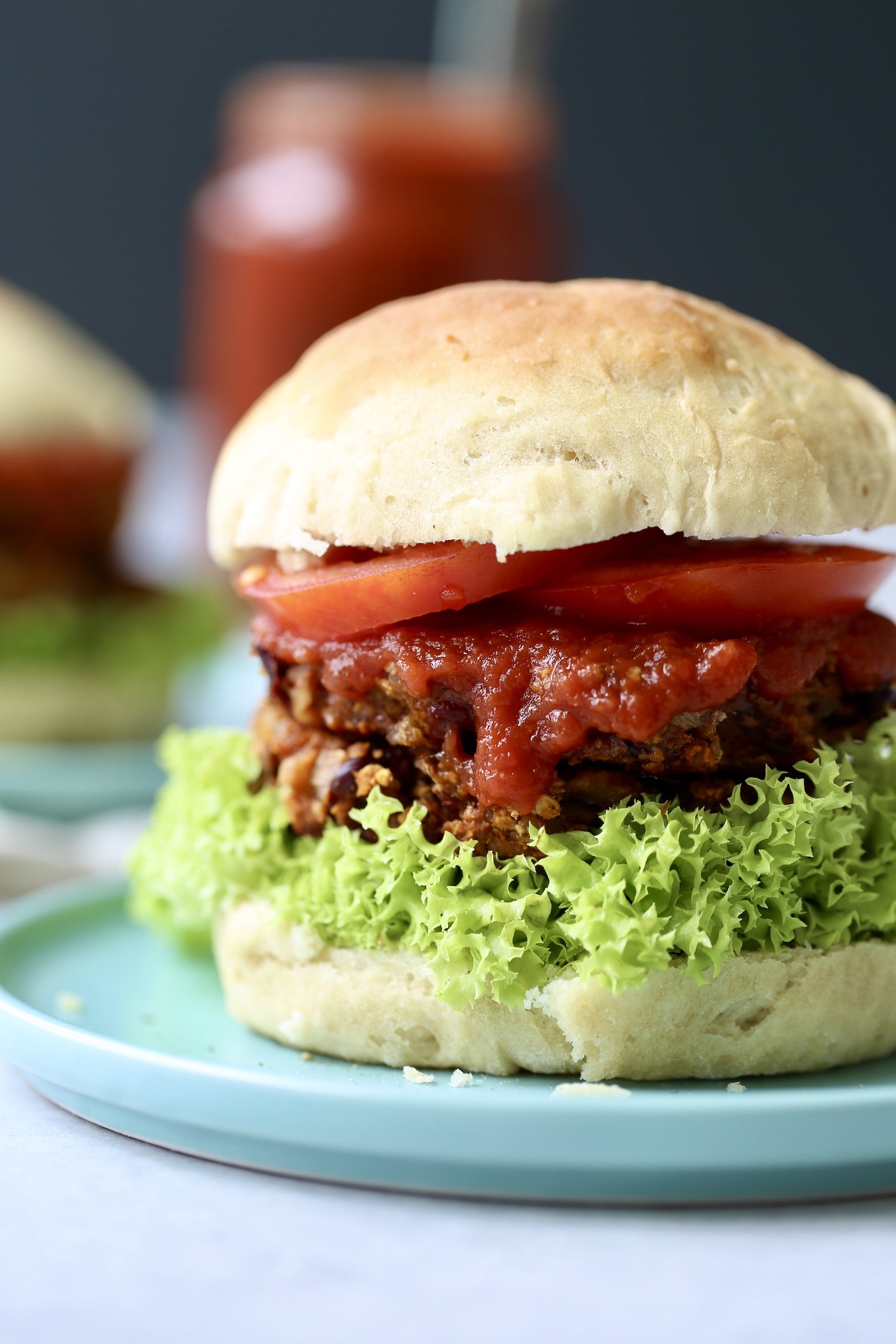 a loaded veggie burger with bbq sauce lettuce and tomato,