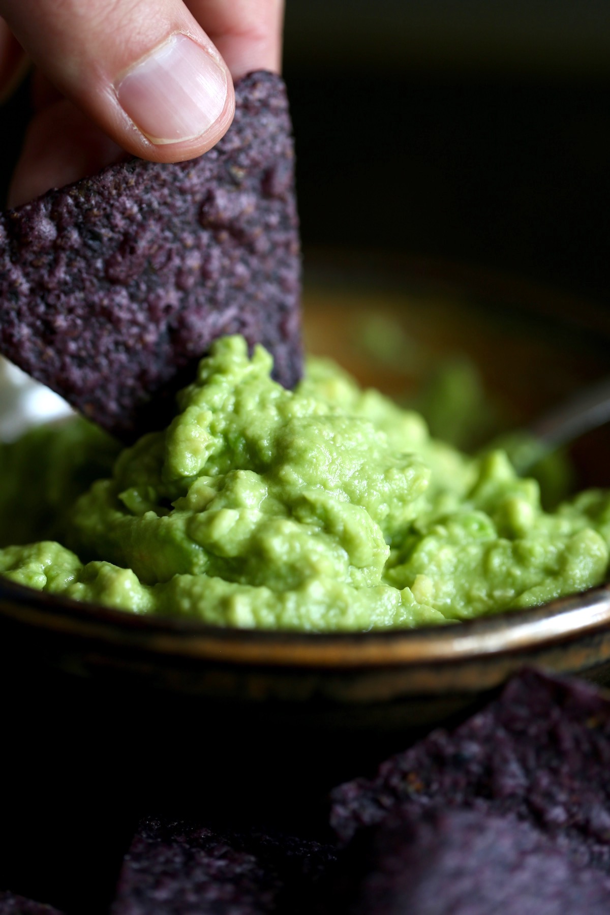 easy homemade guacamole being scooped up with a tortilla chip