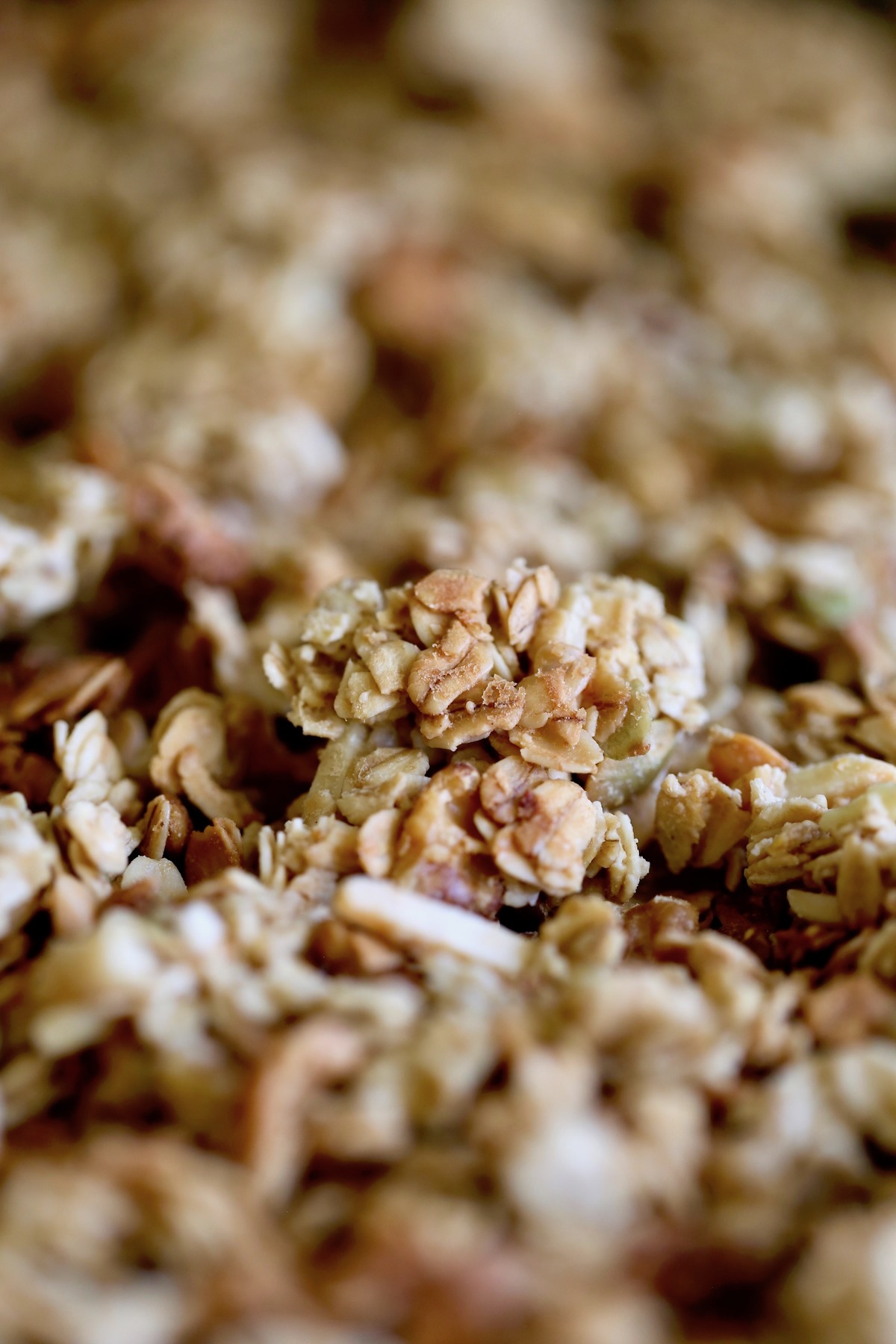 A close-up of a huge cluster of tahini granola on a baking sheet.