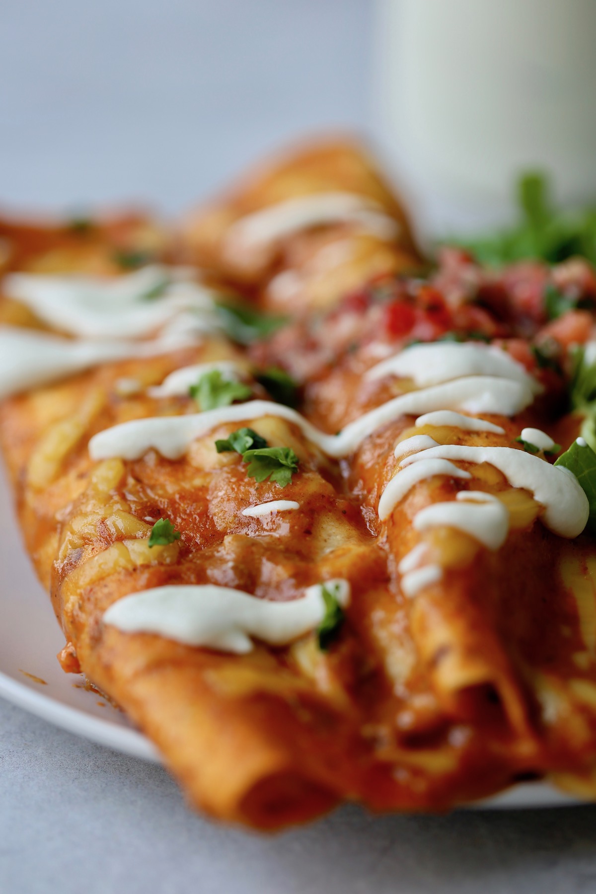 Vegan enchiladas topped with cashew sour cream, green cilantro and fresh salsa.