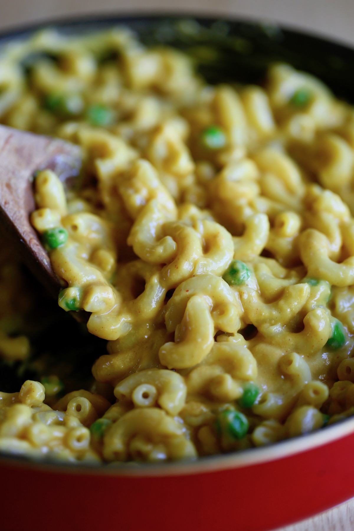 creamy vegan mac & cheese being stirred in a pot