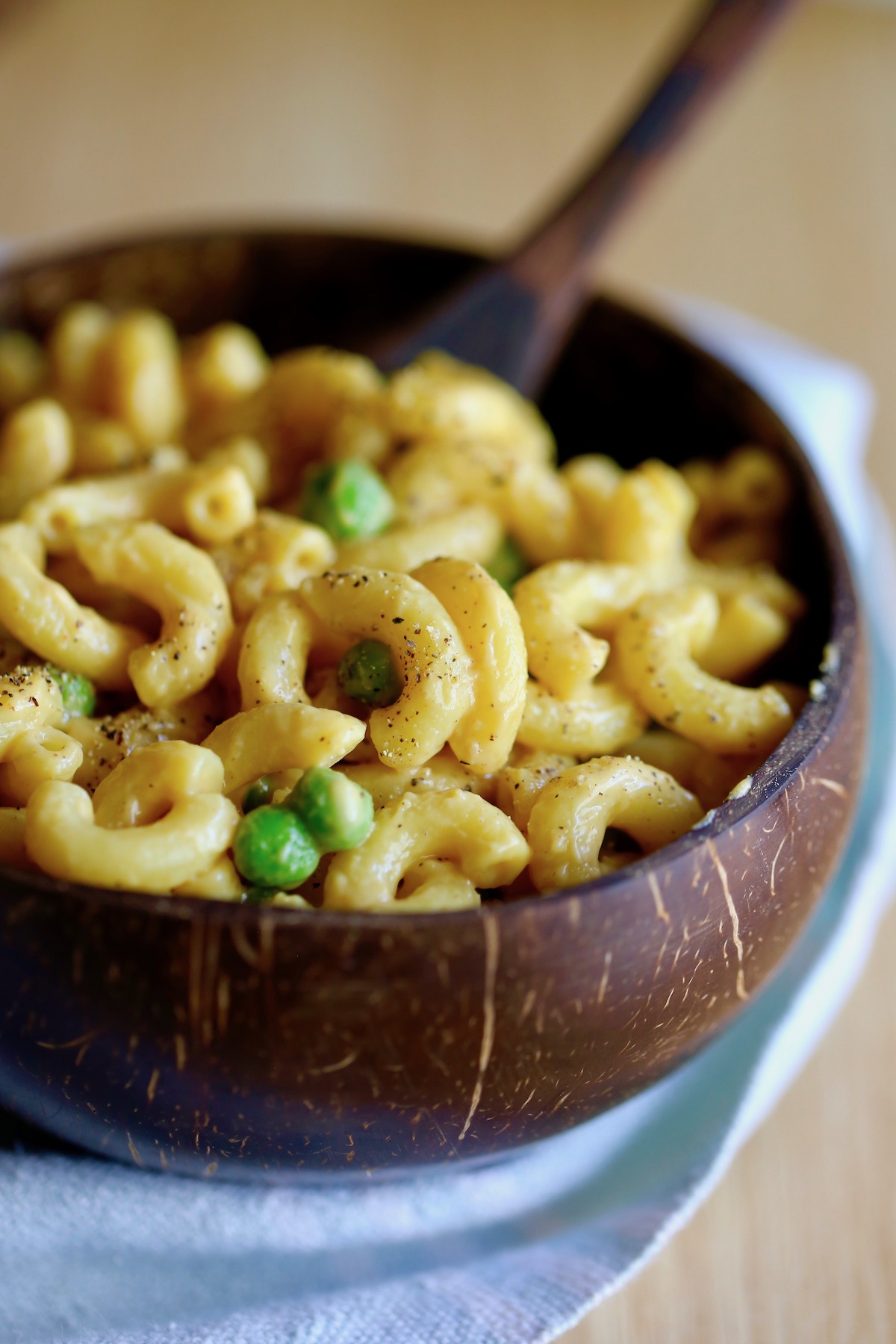 black pepper sprinkled over vegan mac and cheese with peas