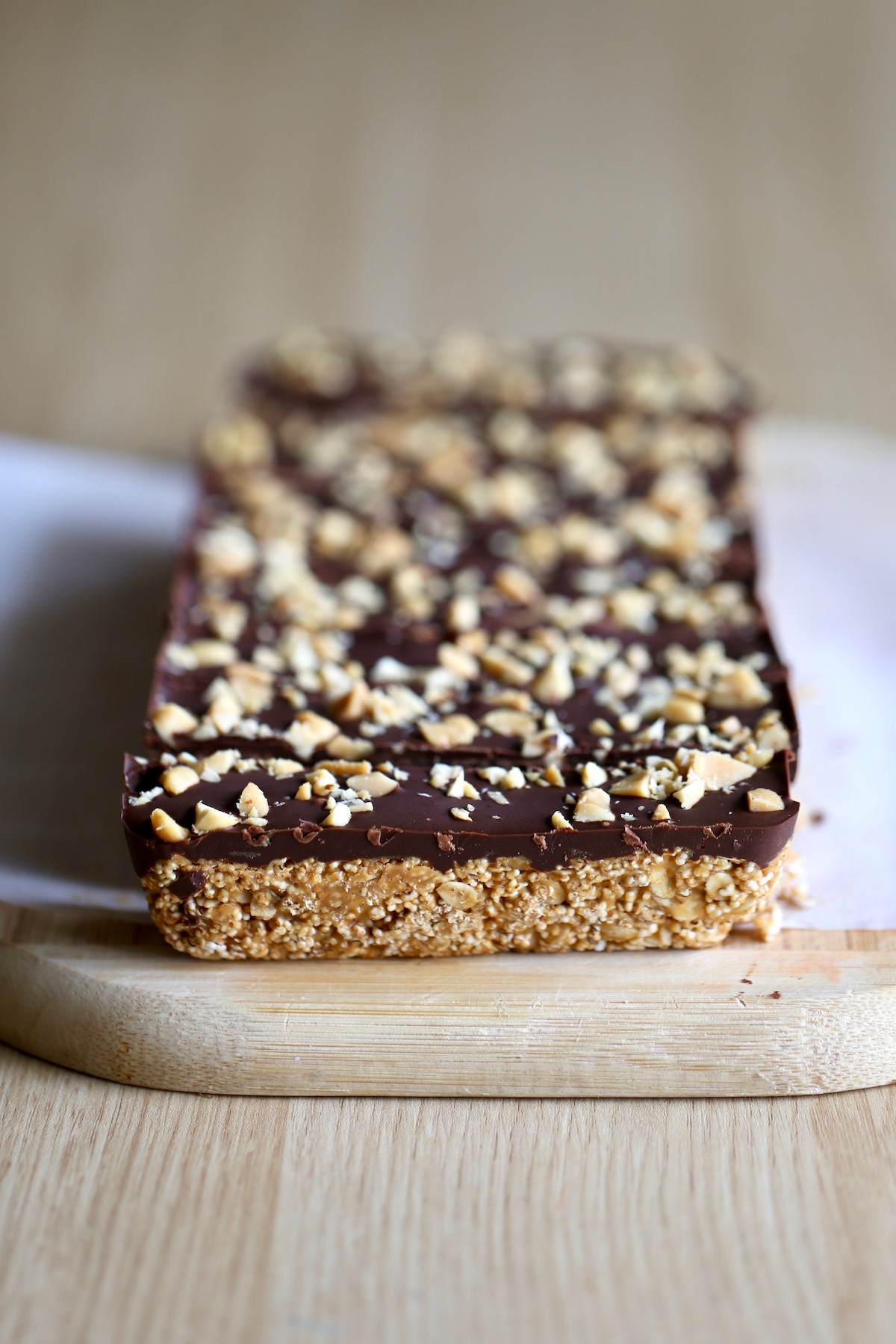 a slab of peanut butter bars on a cutting board after they've been cut into strips