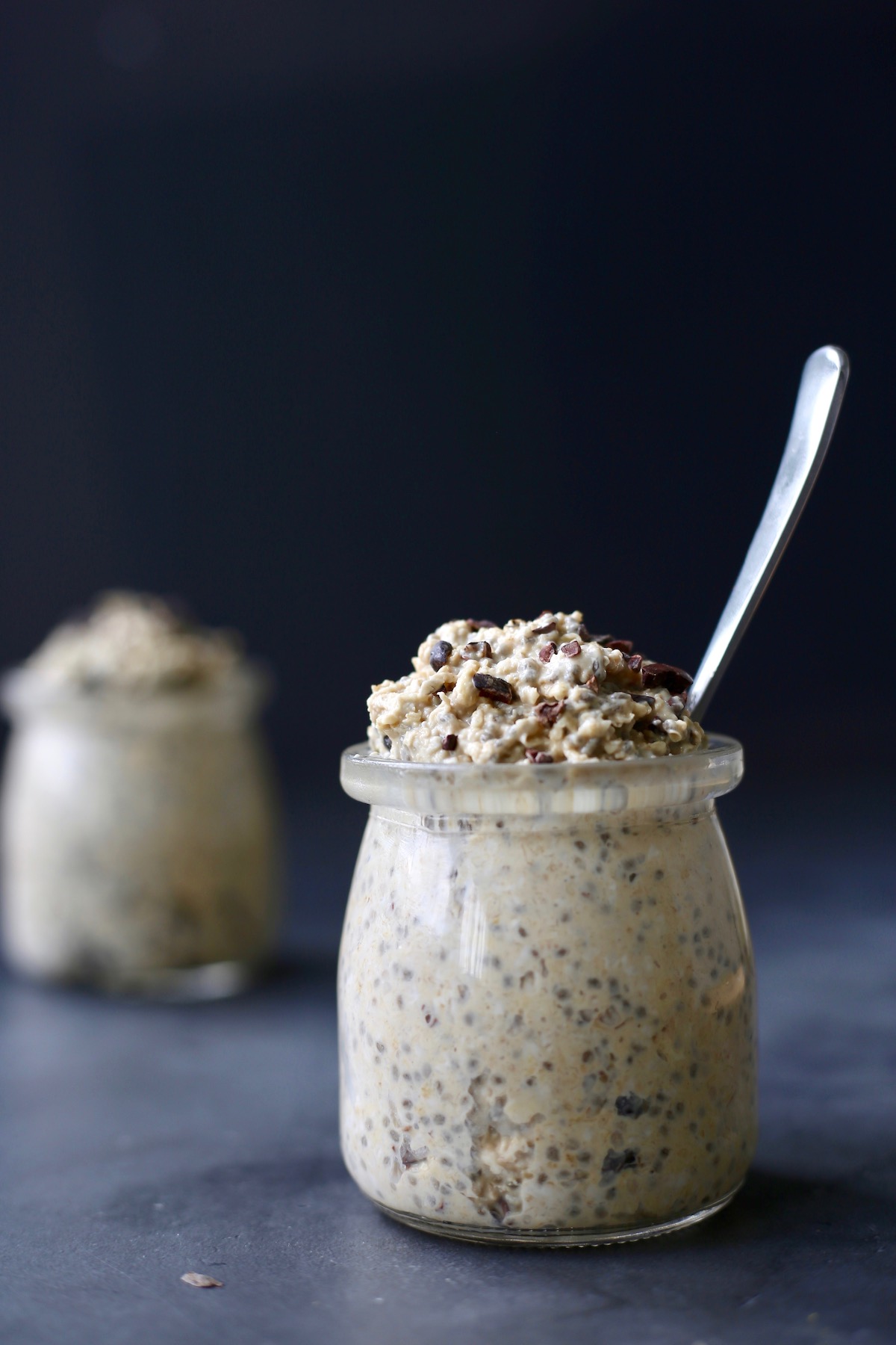 Two small clear jars filled to overflowing with cookie dough overnight oats.