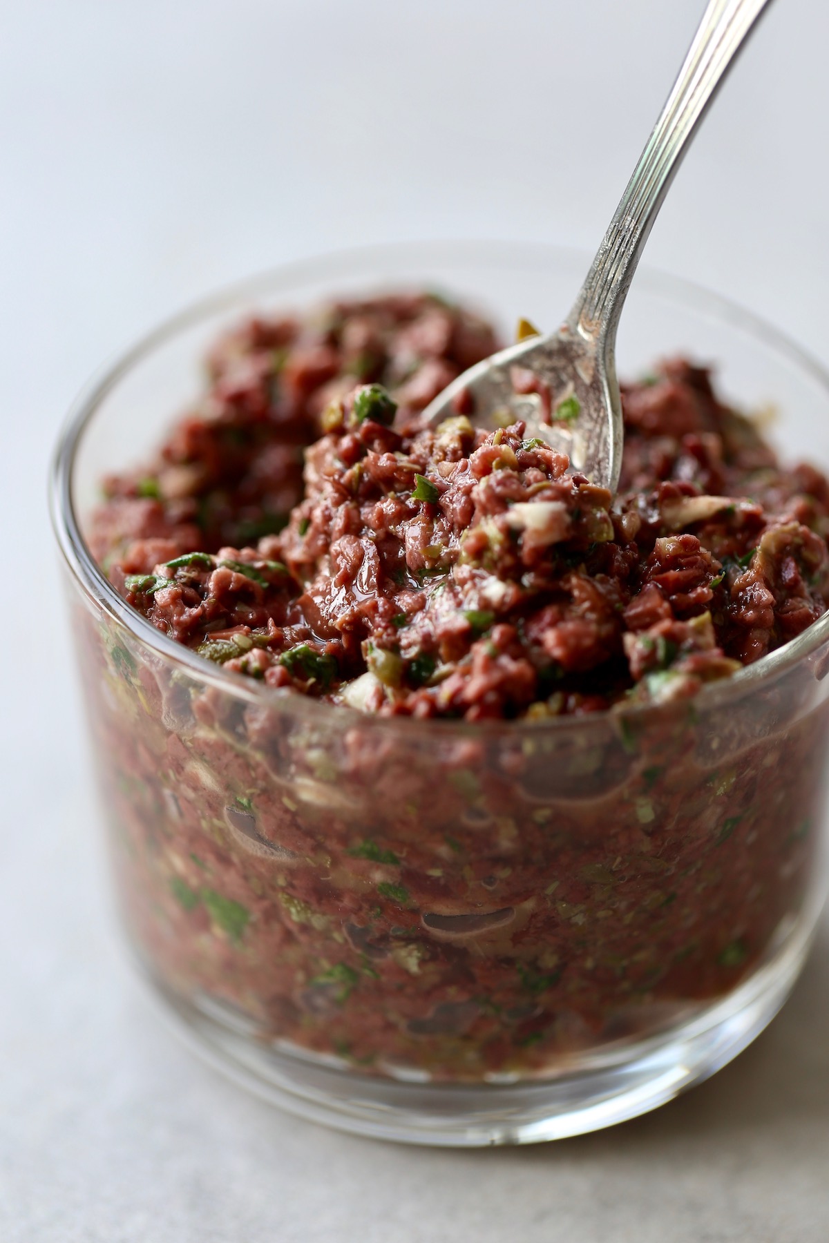 Homemade tapenade being scooped up with a spoon