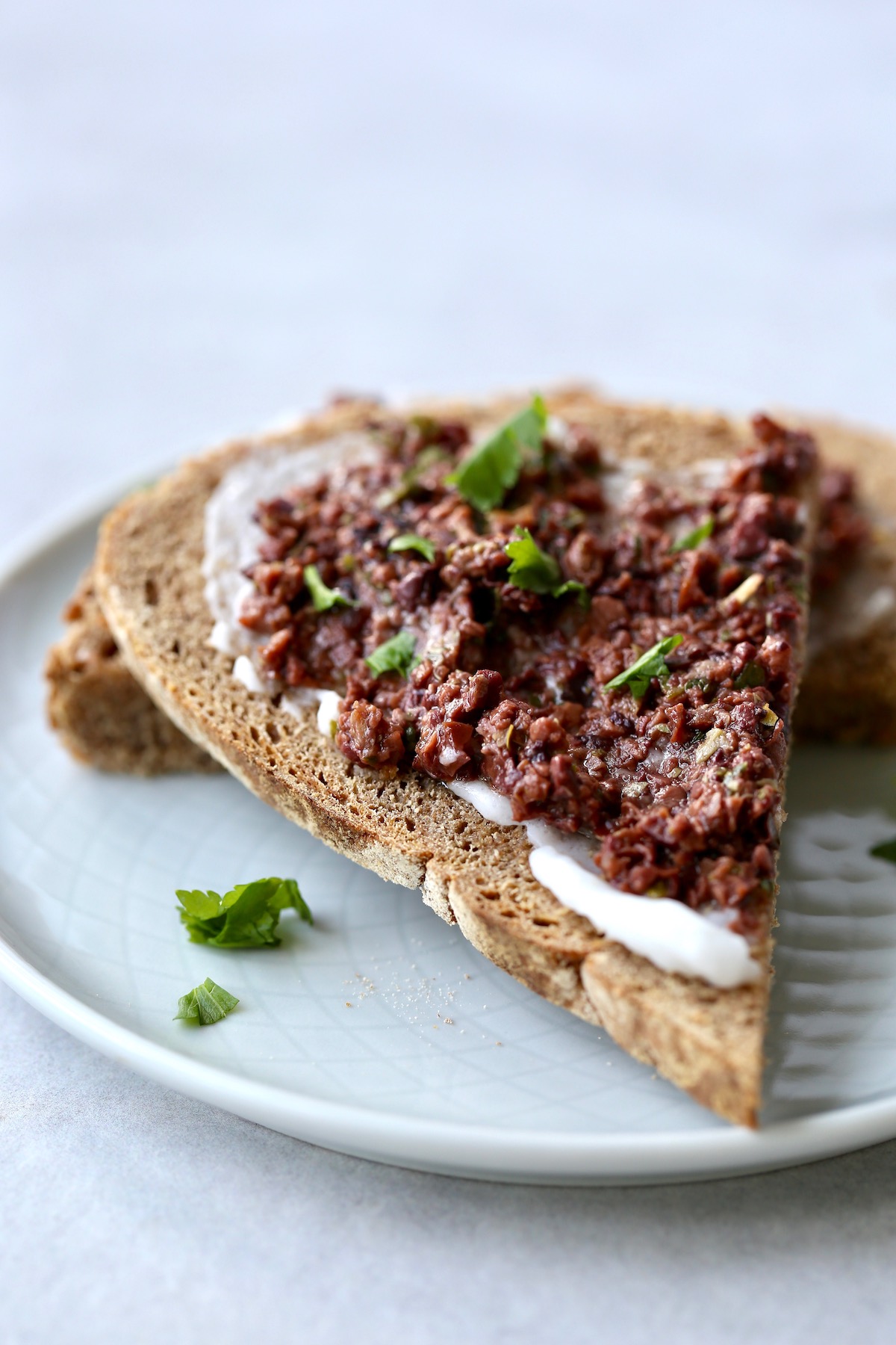 cream cheese and tapenade smeared on some homemade artisan bread