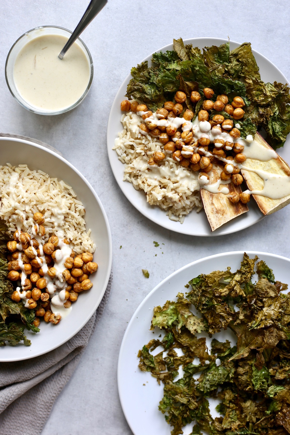 Buddha bowls with brown rice, chickpeas and kale drizzled with homemade lemon tahini dressing