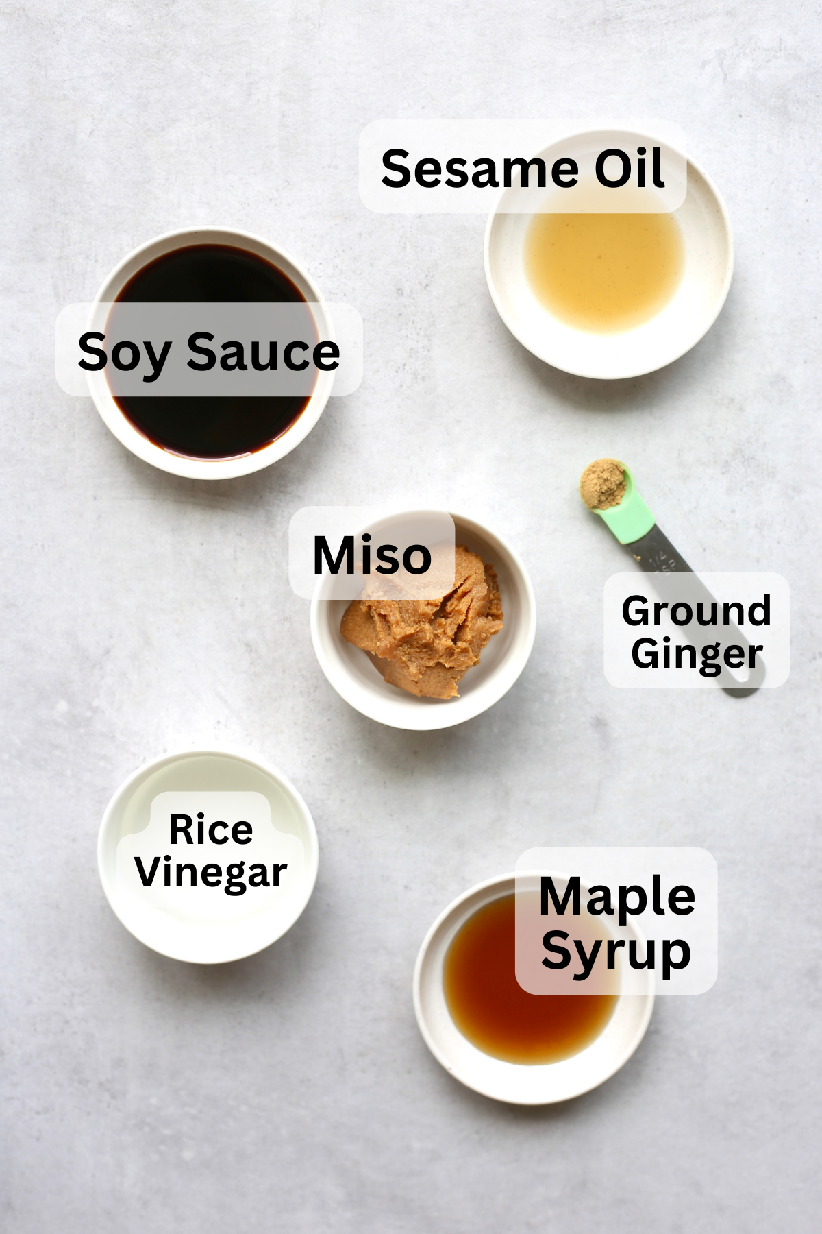 Soy sauce, white miso, maple syrup, sesame oil, rice vinegar and ground ginger measured out into bowl for making miso noodles.