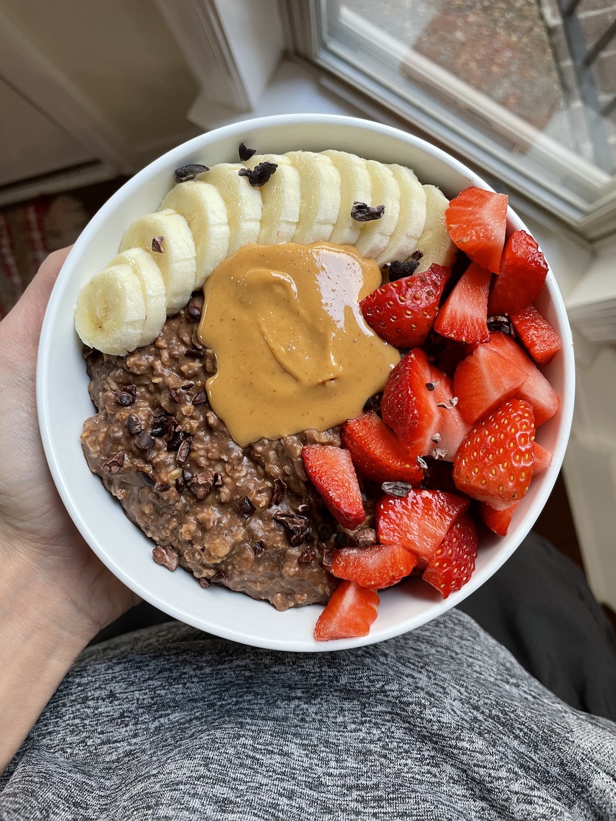 zucchini chocolate oatmeal topped with fruit and peanut butter