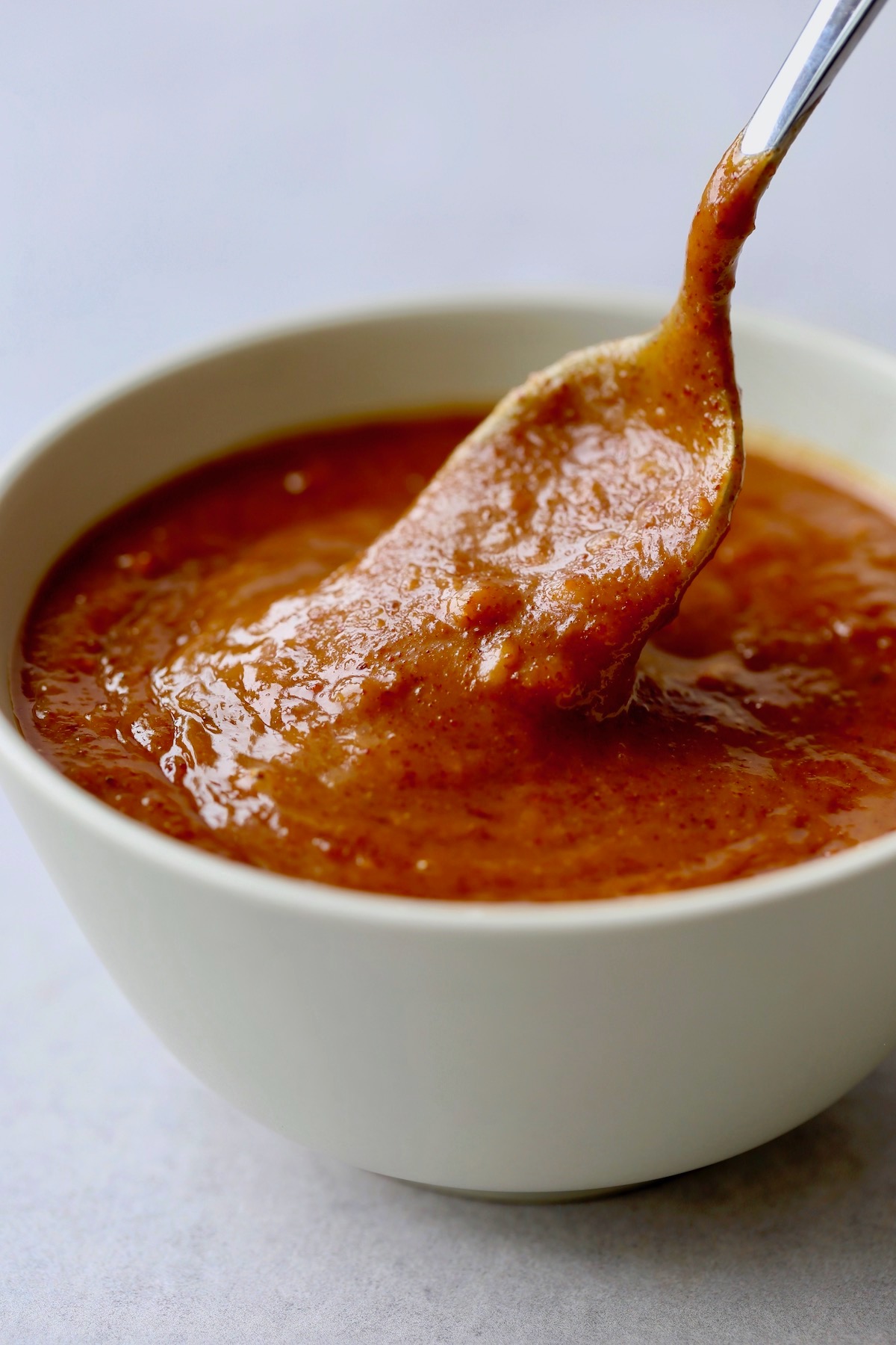 Vegan peanut satay sauce being stirred in a bowl