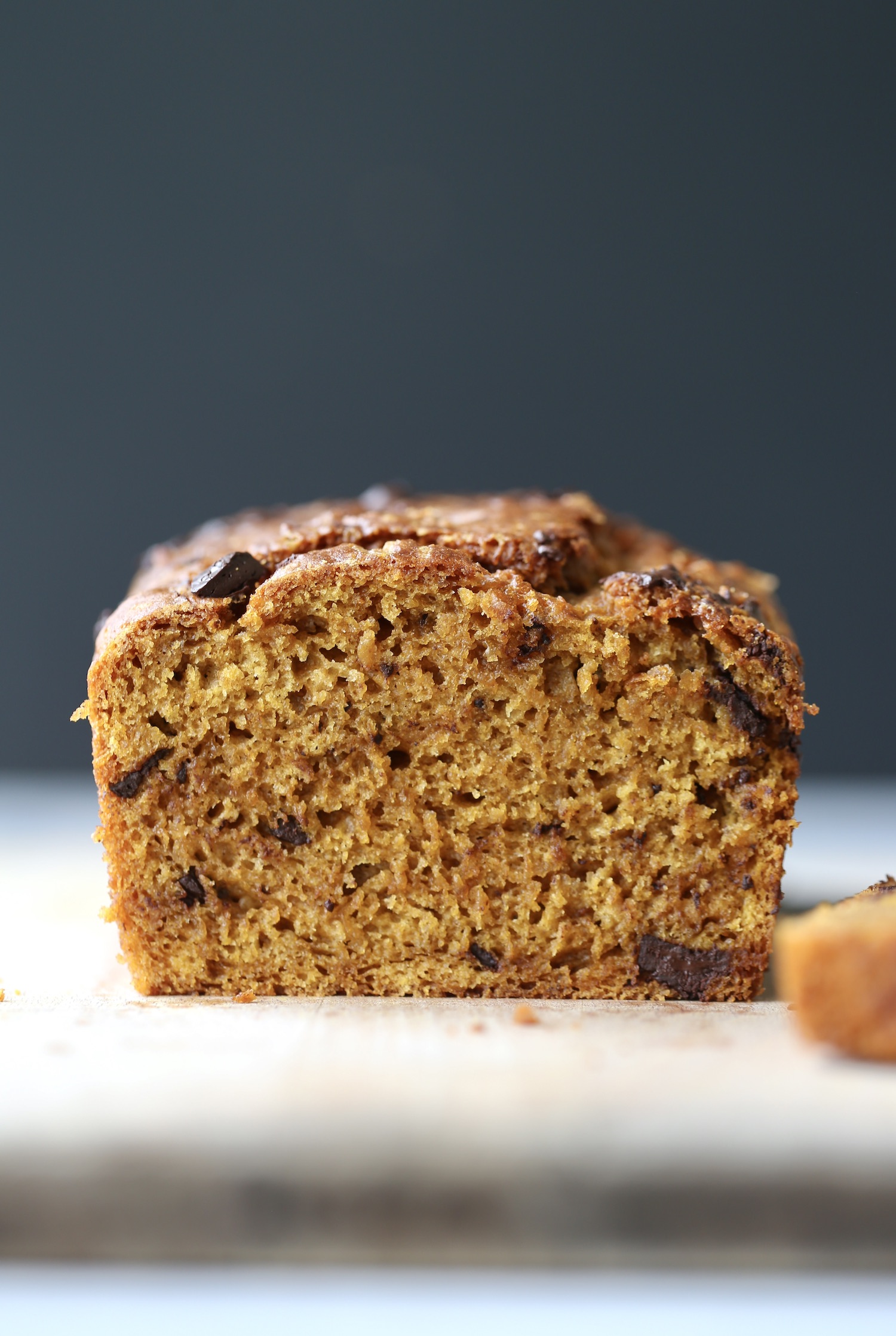 An inside shot of vibrant orange sourdough pumpkin bread with chocolate chunks in it. 