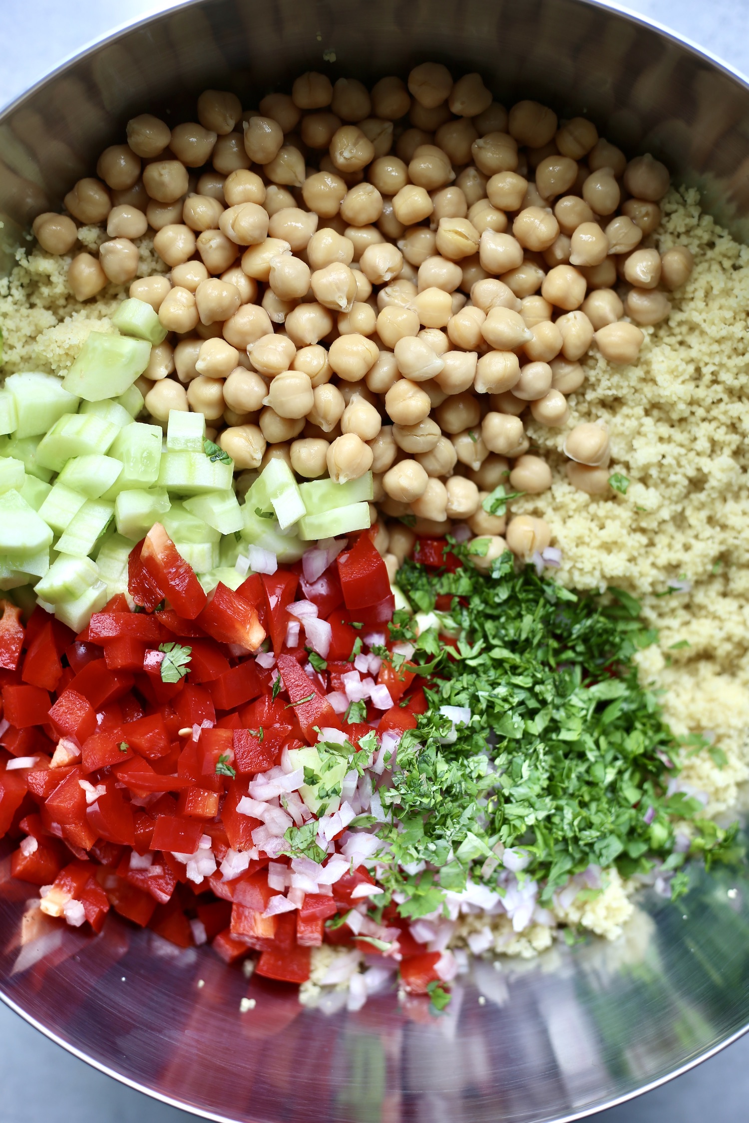 chickpeas, couscous, cucumber, bell pepper, red onion and cilantro in a large mixing bowl