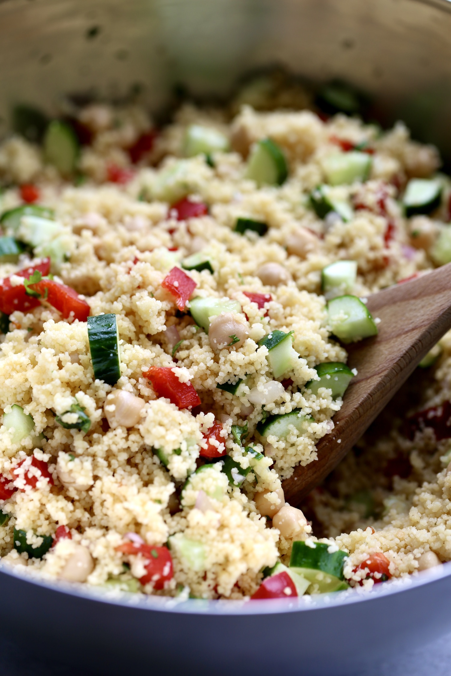 colorful veggies and chickpeas mixed with couscous in a large mixing bowl