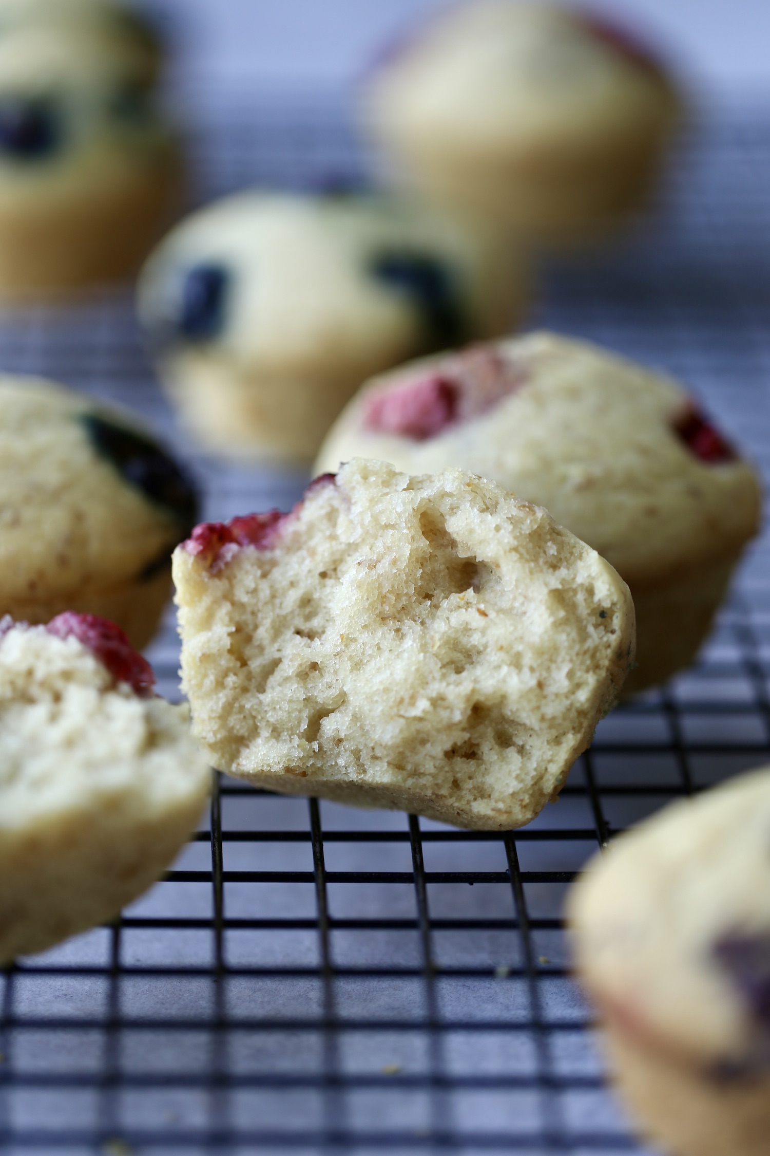 An inside shot of a fluffy, yellow strawberry sourdough muffin. 