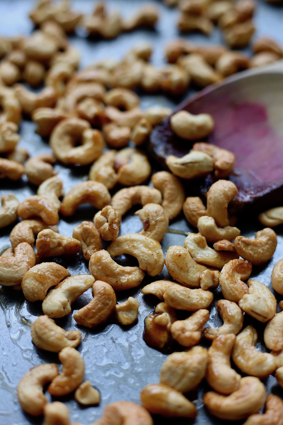 Perfectly roasted candied spicy cashews on a baking sheet.