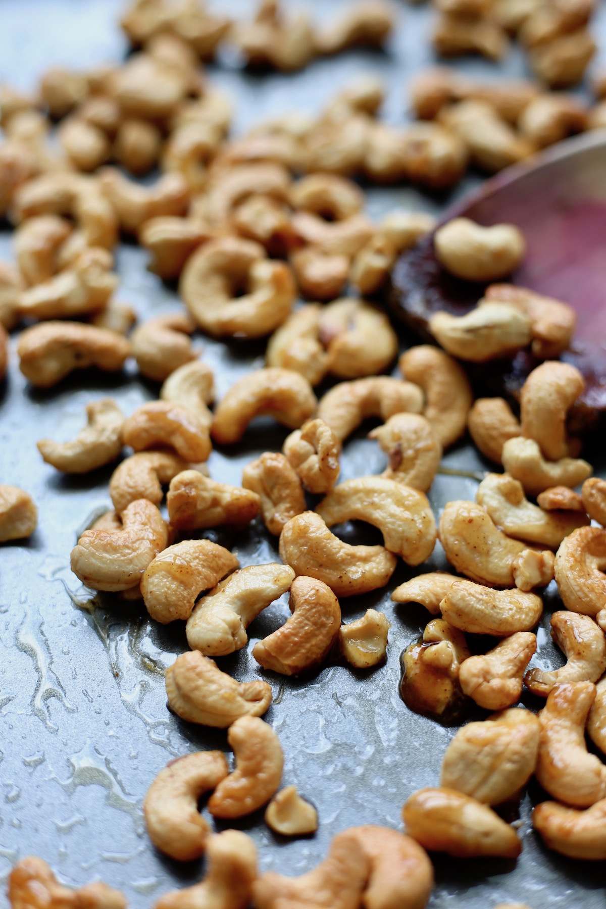 Sweet and spicy roasted cashews on a baking sheet.