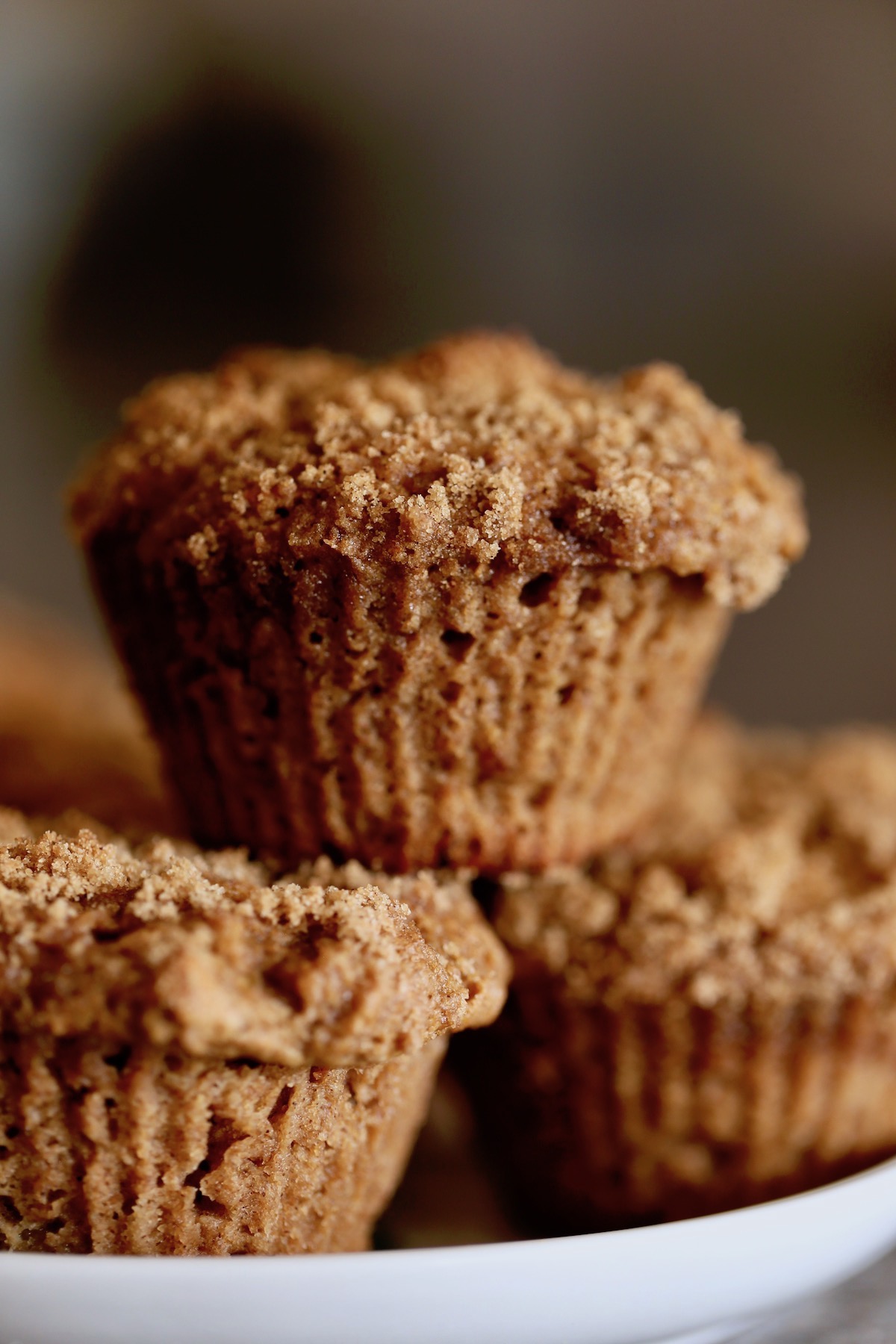 vegan apple crumb muffins stacked on a plate