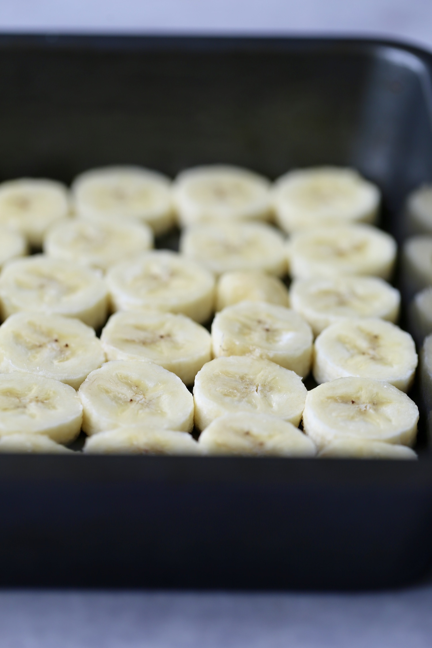 sliced bananas on the bottom of a baking dish