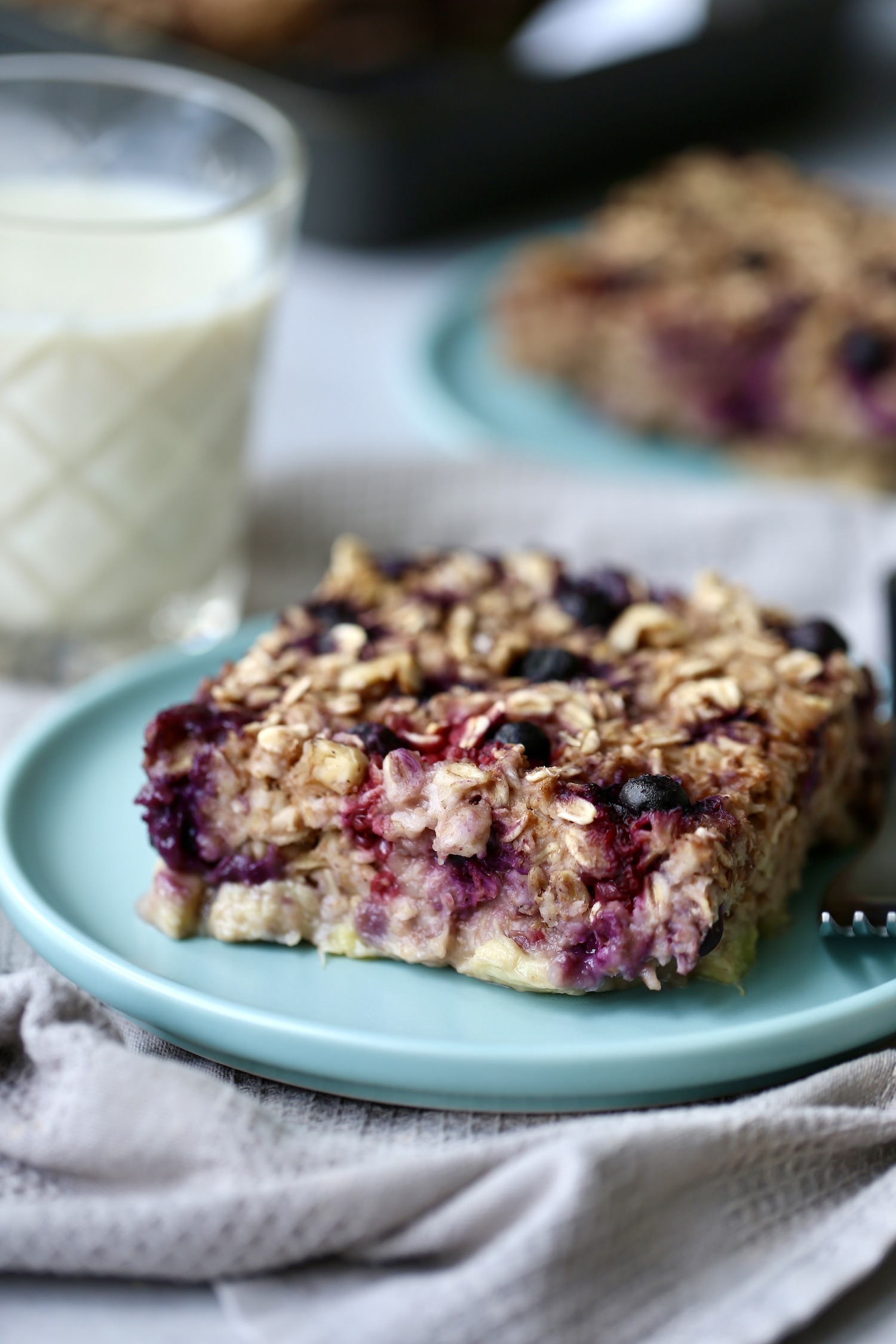 a thick slice of baked oatmeal with berries and walnuts