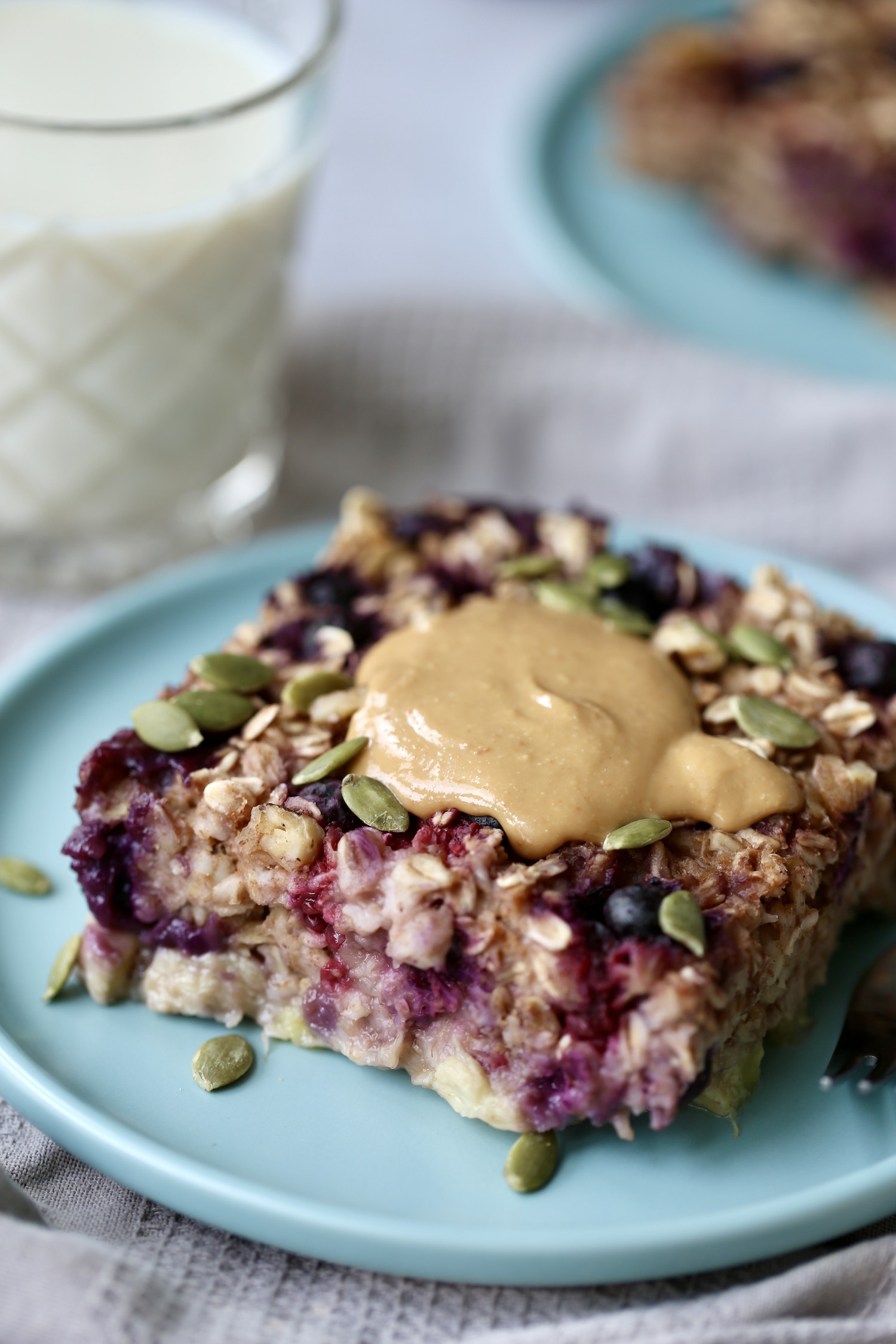 vegan berry baked oatmeal topped with pumpkin seeds and peanut butter