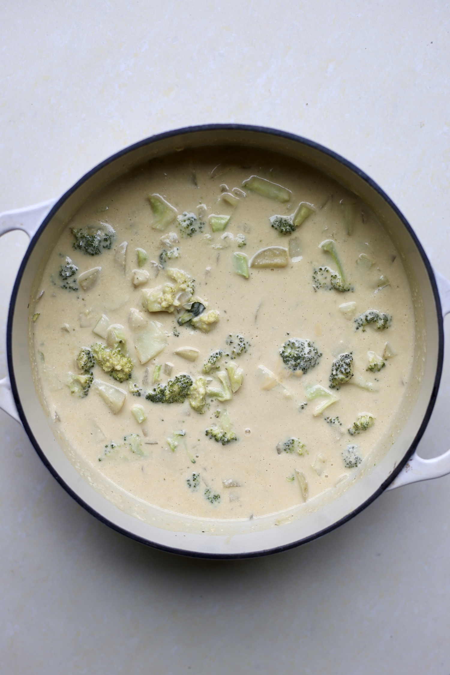 Creamy, cheese vegan broccoli cheddar soup in a large white soup pot. 