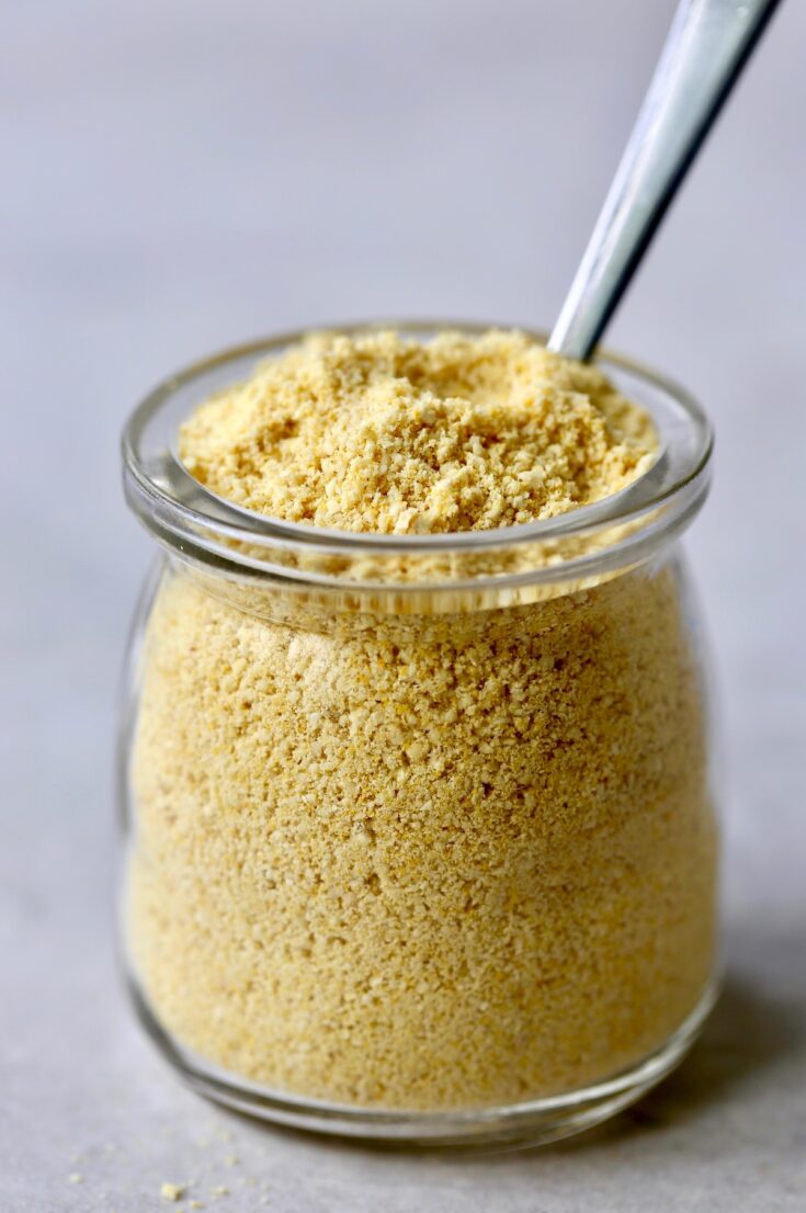 Vegan Cashew Parmesan Cheese in a small bottle with teaspoon