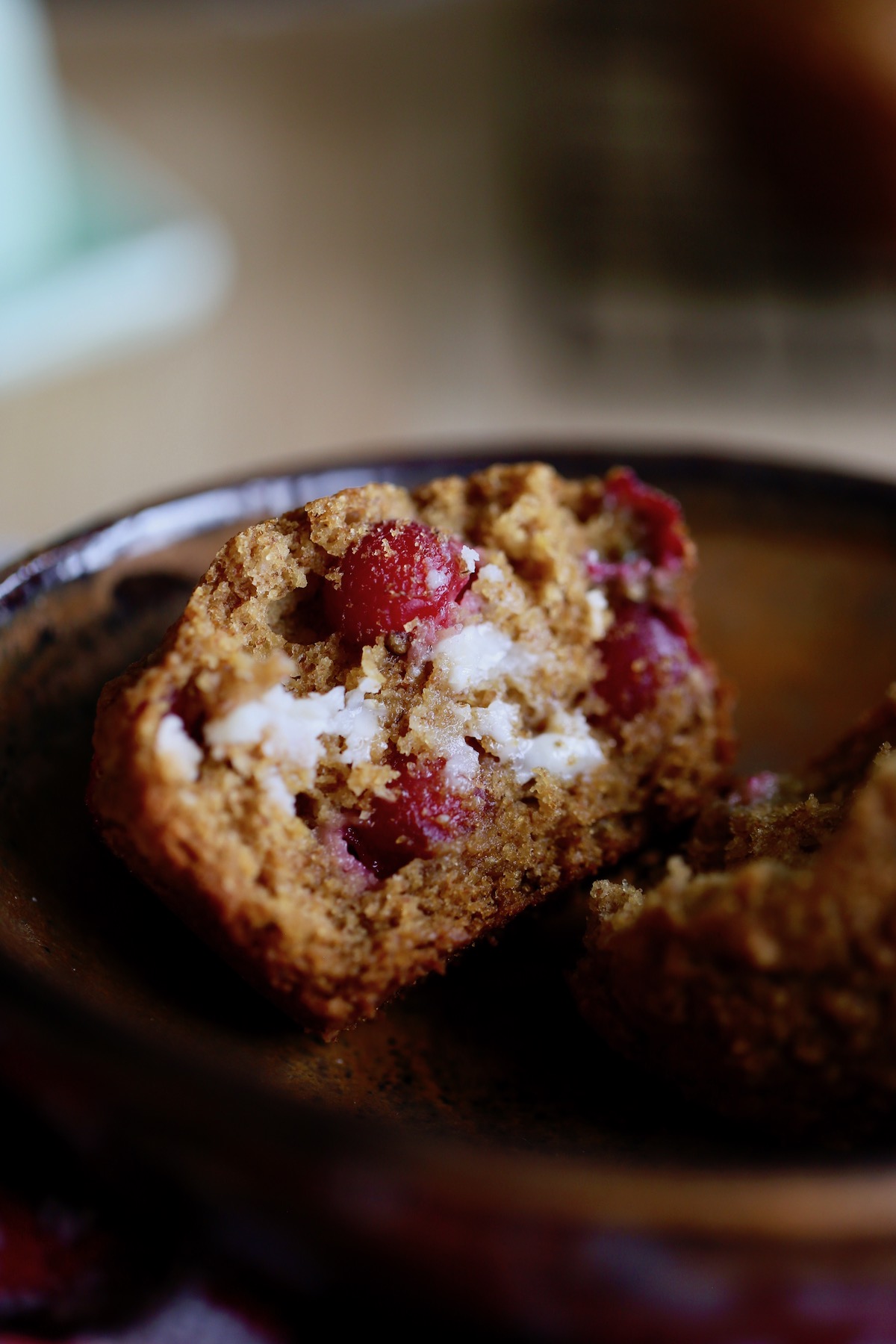 butter melting on a cut up cranberry orange muffin