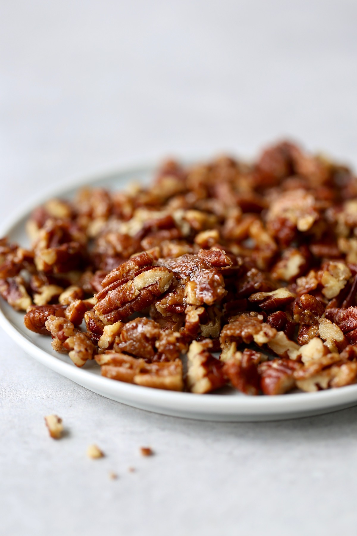 vegan candied pecans cooling on a plate