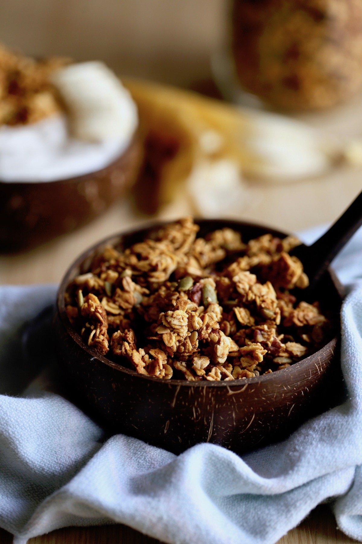 vegan pumpkin granola piled high in a coconut bowl