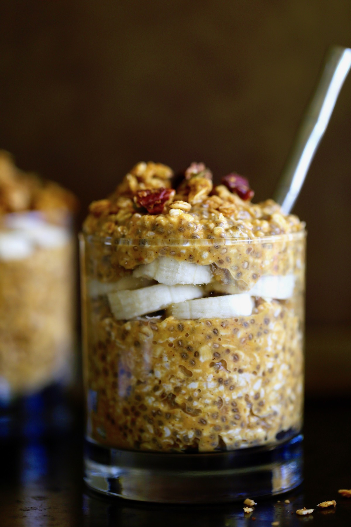 vegan pumpkin pie overnight oats layered with banana slices and granola in a glass jar