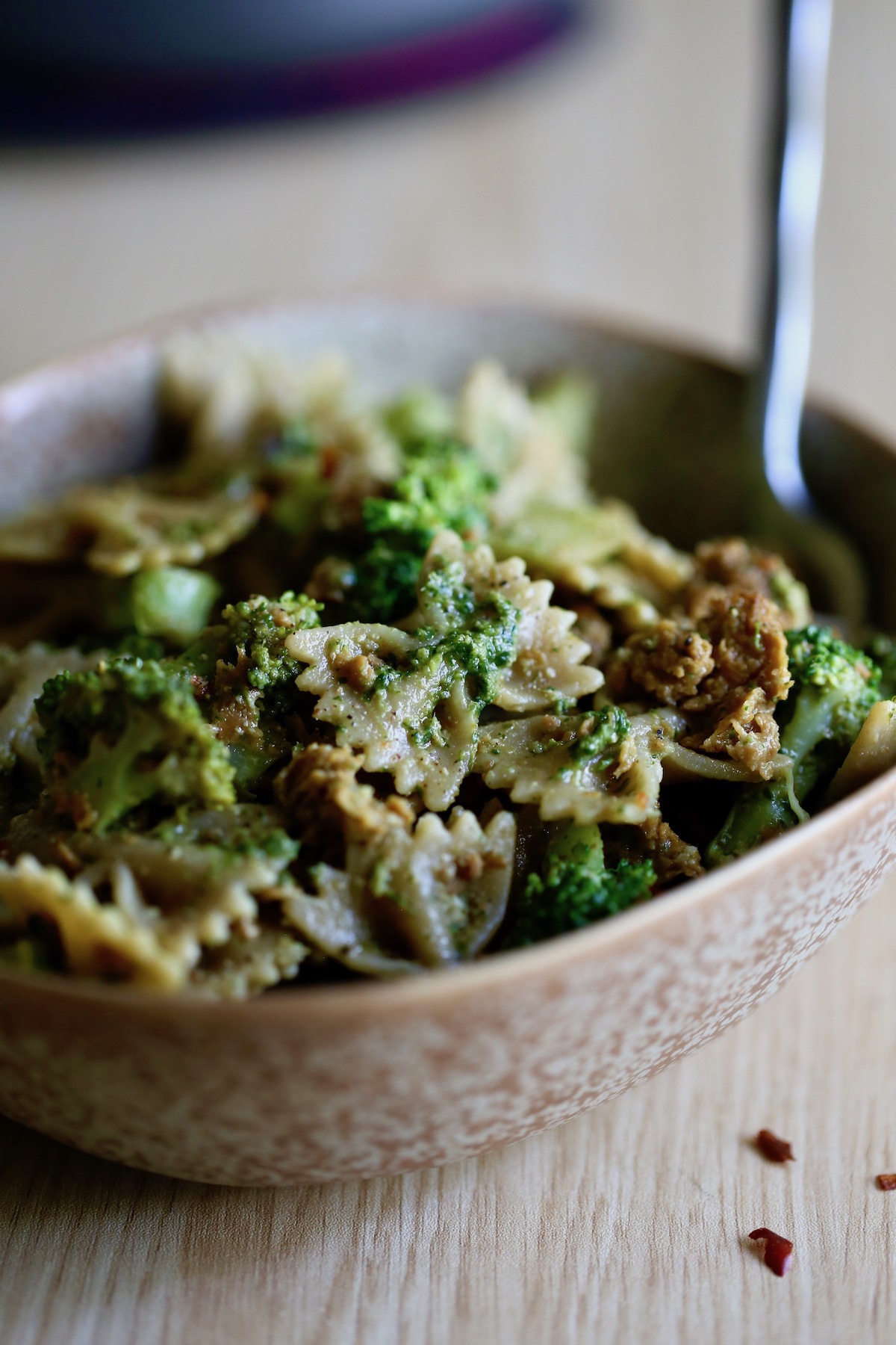 Vegan pesto pasta with sausage and broccoli piled high in a bowl