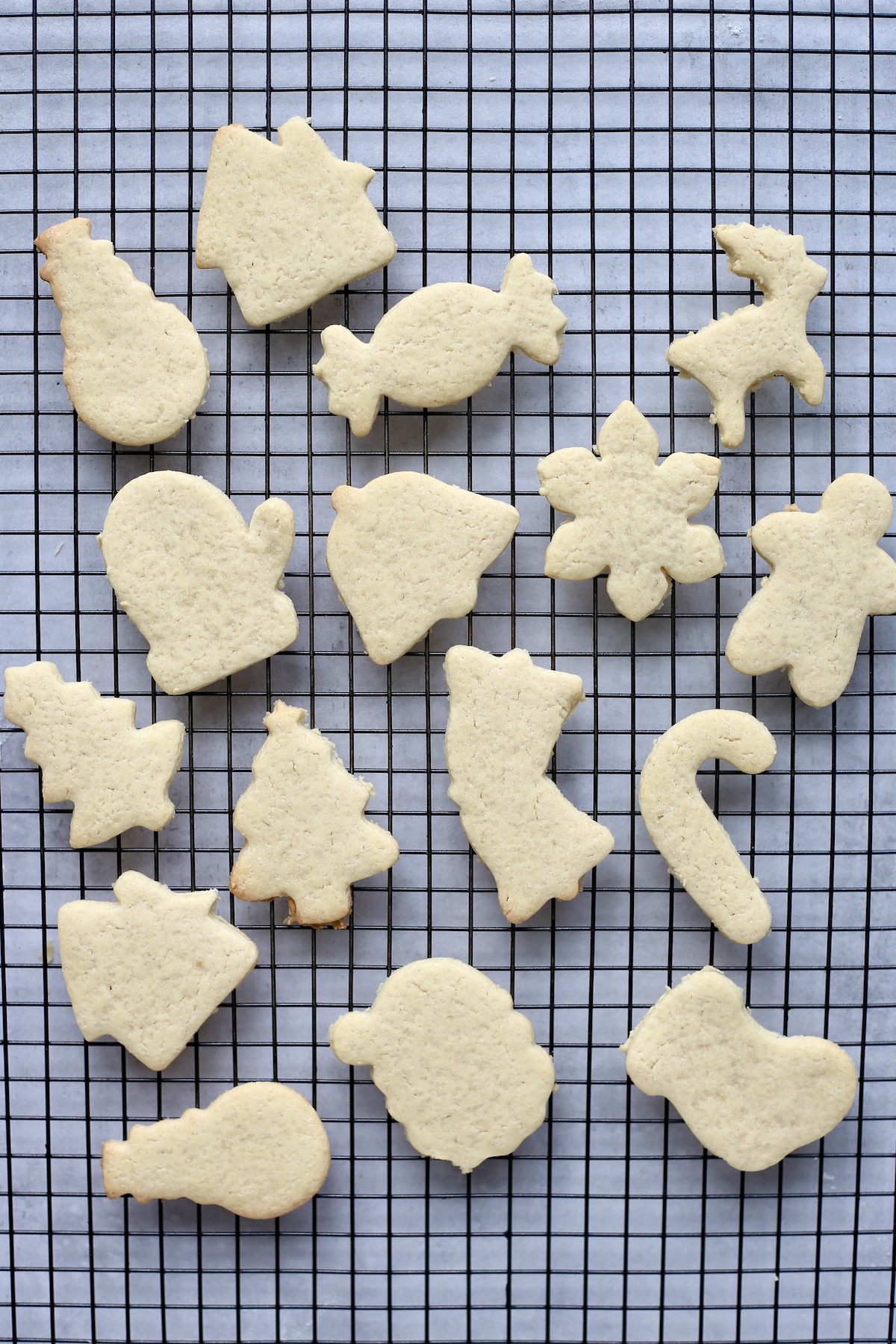 An overhead shot of vegan sugar cookies cooling on a black wire rack.