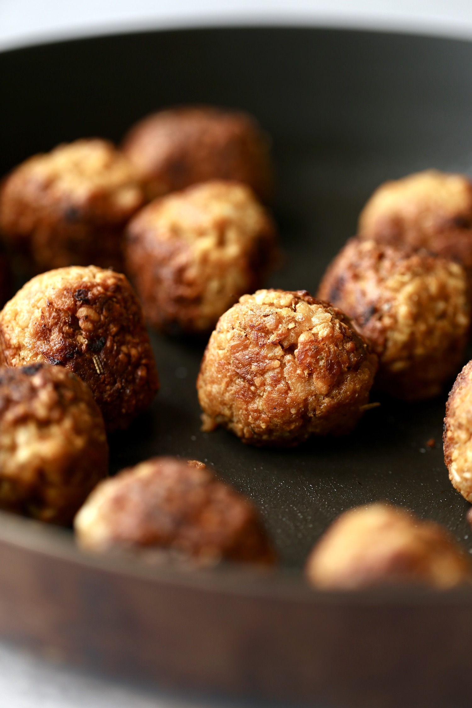 vegan tempeh meatballs browning on a skillet