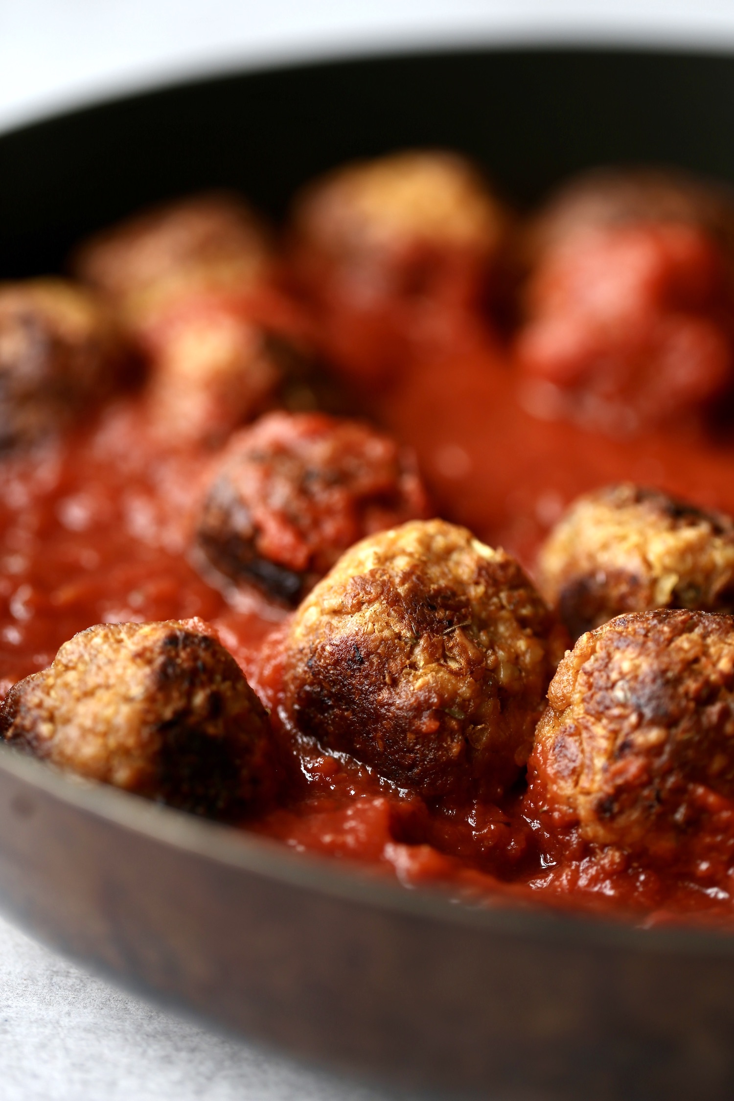 tempeh meatballs simmering in marinara sauce