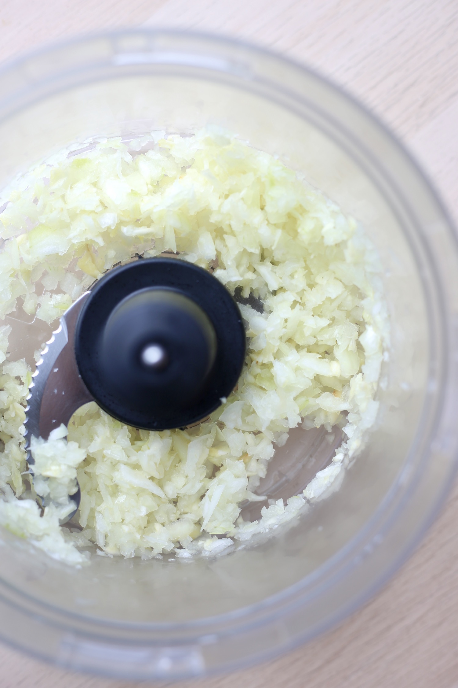 Onions being chopped up in a food processor. 